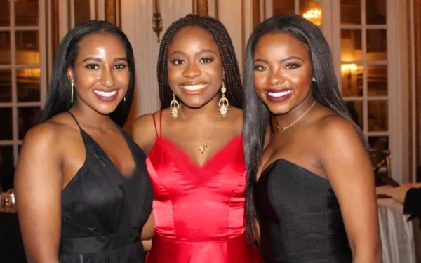 My two best friends and I, smiling, at a gala.