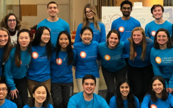 Group of smiling students in blue shirts