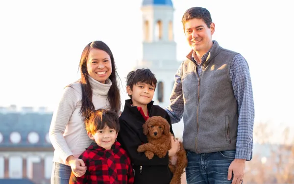 A portrait of Leslie Duhaylongsod and Eric Beerbohm, faculty deans of Quincy House, with their two sons and dog.