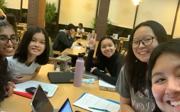 Five girls studying in a college dining hall.