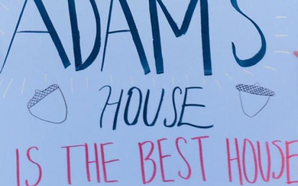 A picture of a white poster with "Adams House is the Best House" written on it.