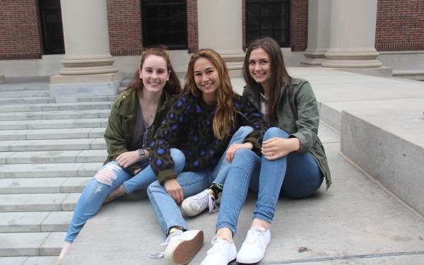 Three friends sitting in front of Widener Library