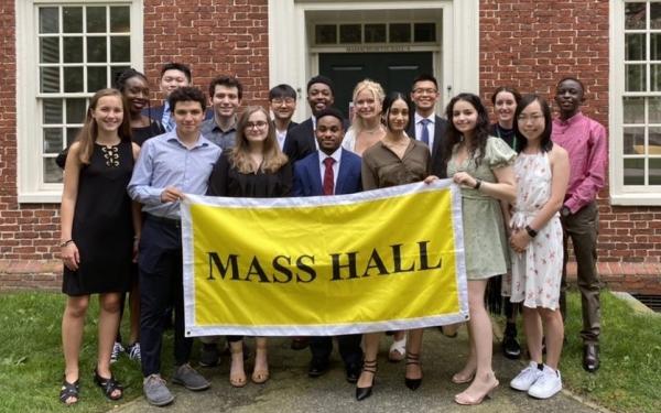 A picture of Mass Hall residents holding a yellow "Mass Hall" banner.