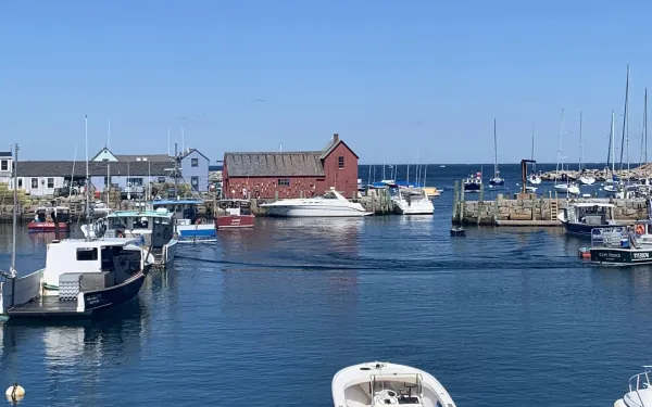 A red farmhouse surrounded by water and boats.