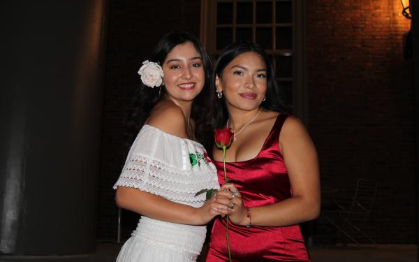Latinx convocation a celebration for first years. Two girls holding a red rose.