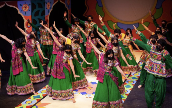 Group of women dancing in green and pink outfits 