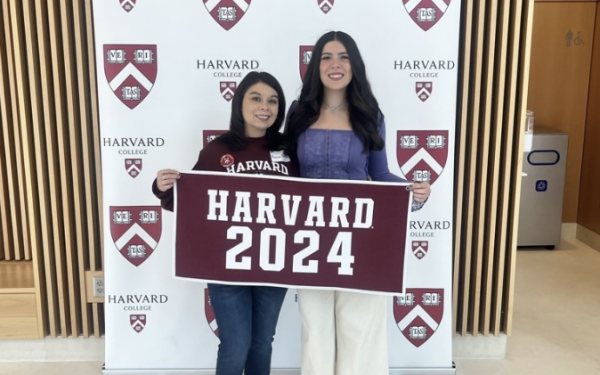 Mom and Daughter smiling with Harvard 2024 sign