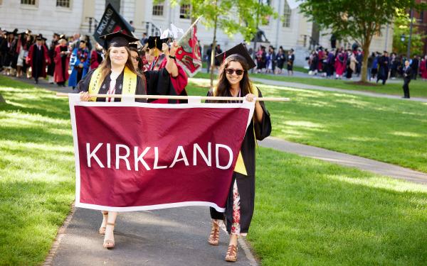 Hannah and a friend carry the Kirkland House banner at Commencement.