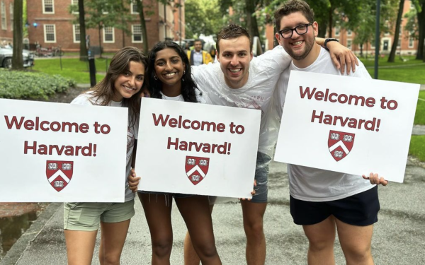 Students holding "Welcome to Harvard!" signs