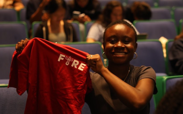 student holding up FYRE t shirt