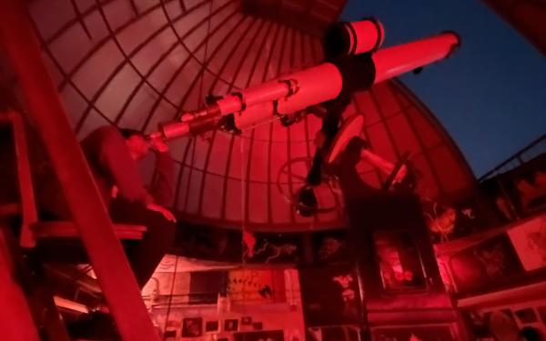 Rafid looking out through the Loomis-Michael student observatory telescope