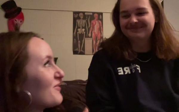 Two students sitting in a dorm room. 