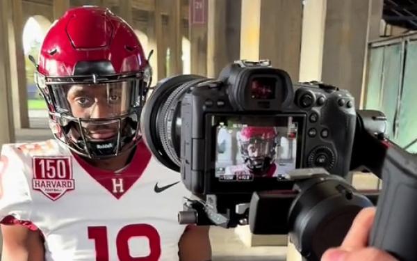 A Harvard football player standing in front of a camera.