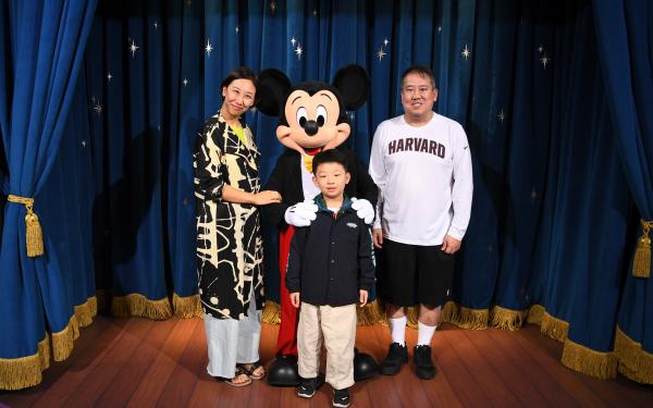 Family photo of David Yoon with wife and son and Mickey Mouse
