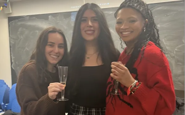 Three girls smiling for a picture. 
