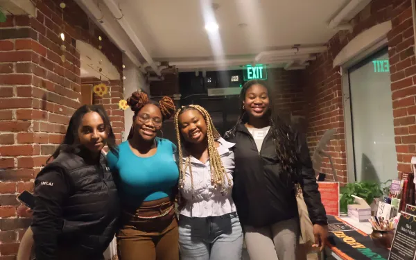 A picture of four black girls smiling and posing for a picture 