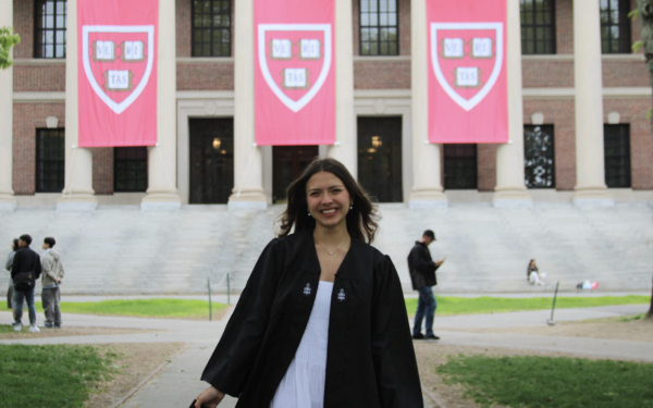 Ana posing in front of the Widener library in her graduation regalia. 