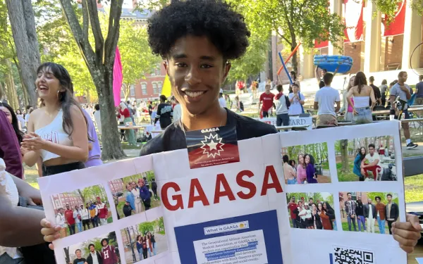 Ricardo holding up a poster board during the student activites fair