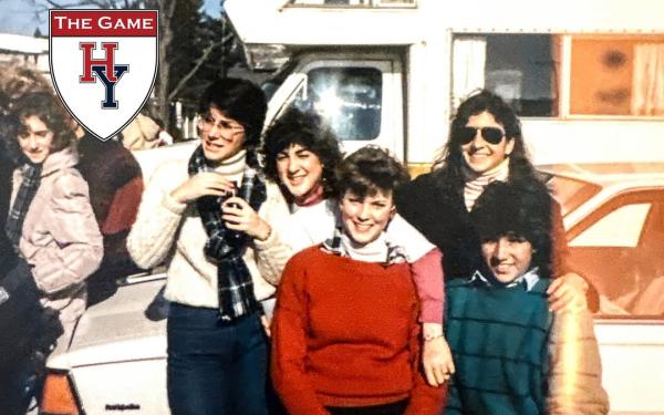 Group of young people posing outside in winter clothes, with a "The Game" Harvard-Yale logo in the corner.