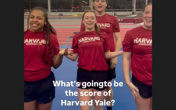 Four Harvard cheerleaders stand in a gym, with text asking, "What's going to be the score of Harvard Yale?"