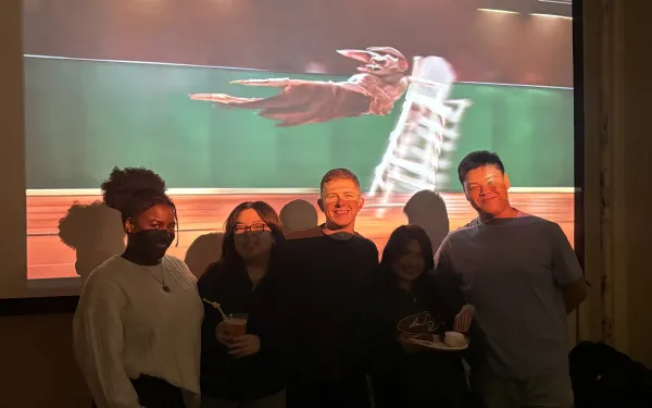 5 people standing in front of a projector screen.