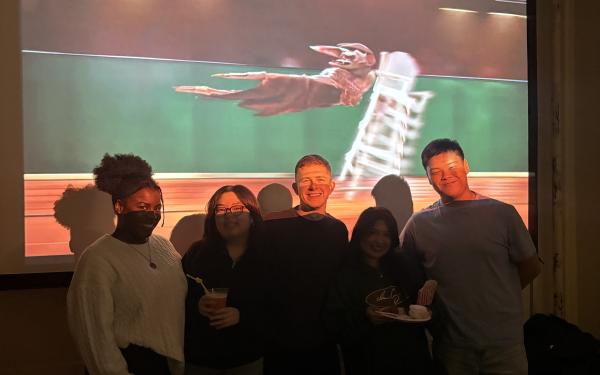 5 people standing in front of a projector screen.
