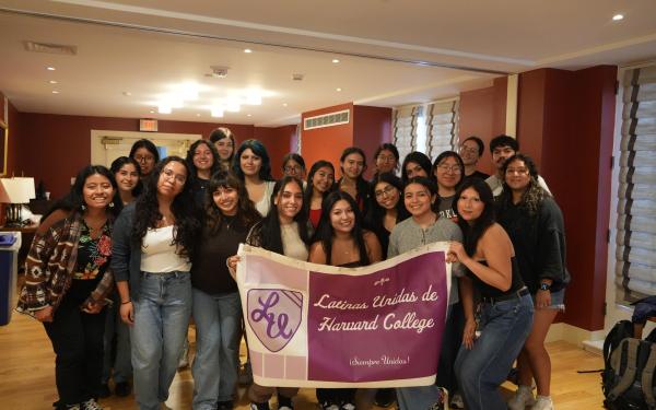A group of students holding a Latinas Unidas de Harvard College banner. 