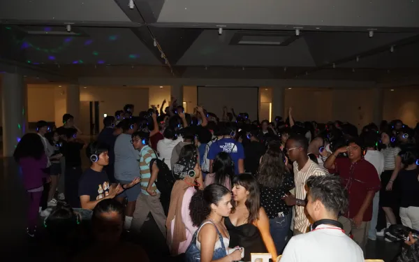 students at a silent disco, with lit up headphones