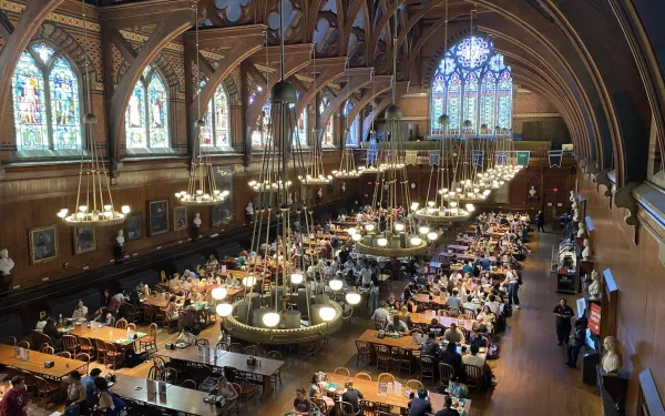 Indoor dining hall with rows of dining tables and stained glass windows