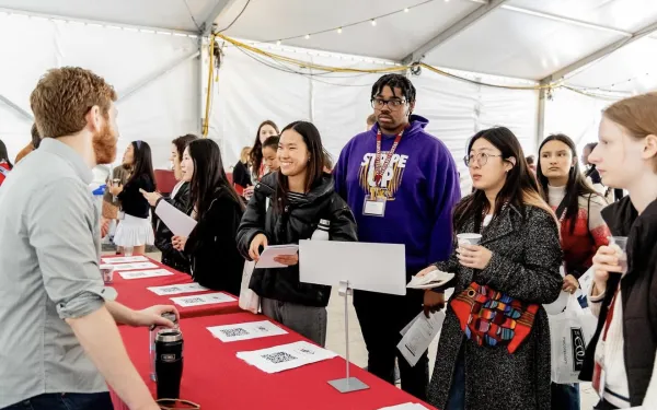Visitas Concentration Fair 2024. Students lined up at table listening to a concentration advisor.