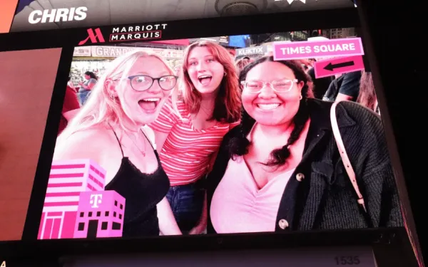 Three friends on a billboard in times square. 