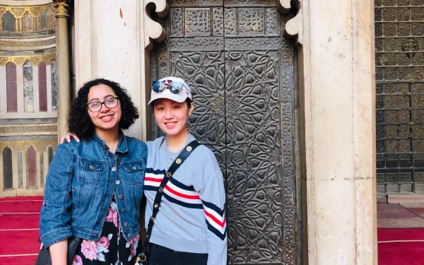 Two students in front of a mosque