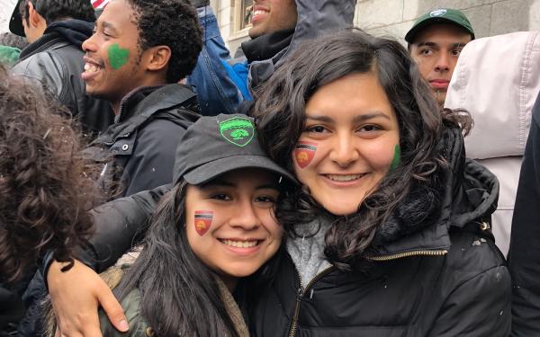 Maria posing with one of her friends who also lives in Currier. They are outside and it is snowing. 