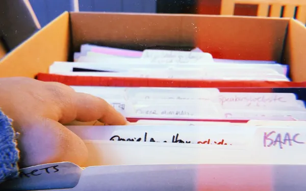 Hand going through files in a box at an archive 